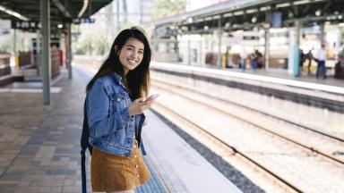 Photo d'une femme souriante sur le quai d'une gare