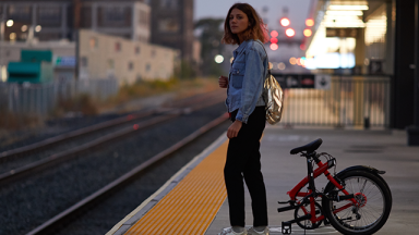 Phot d'une femme avec un vélo pliant sur le quai d'une gare